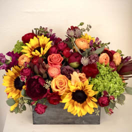 Mixed bouquet in a gray rectangular box with sunflowers and roses