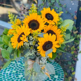 Bouquet of yellow sunflowers in a glass vase