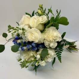 White roses and carnations with blue flowers in a vase