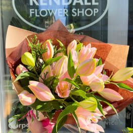 Bouquet of pink and yellow tulips wrapped in brown paper