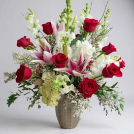 Red roses and pink lilies in a tall textured vase