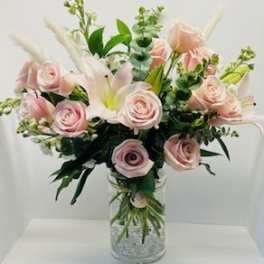 Pink roses and white lilies in a clear glass vase