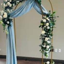 Floral arch with white flowers and blue draping fabric