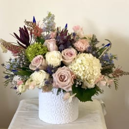 Mixed bouquet of pastel roses and hydrangea in a white vase