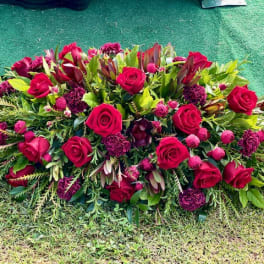 Large red rose and burgundy floral spray on the ground