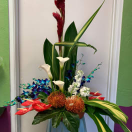 Tropical floral arrangement with red blooms, white calla lilies, and blue orchids