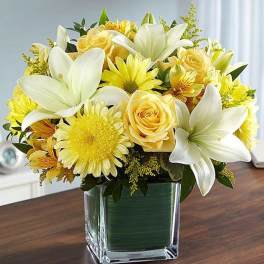 Yellow and white bouquet in a square glass vase