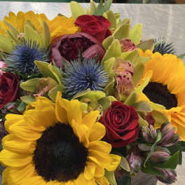 Bouquet with sunflowers, red roses, and blue thistle
