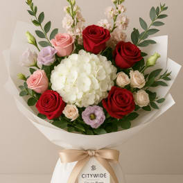 Bouquet of red and pink roses with white hydrangea in white wrap