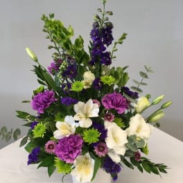 Mixed bouquet in a white vase with purple, white, and green flowers