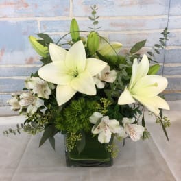 White lilies and white alstroemeria in a square glass vase