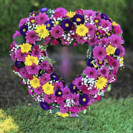 Heart-shaped floral wreath with pink, yellow, and purple flowers
