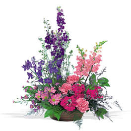 Tall mixed bouquet of purple and pink flowers in a low container