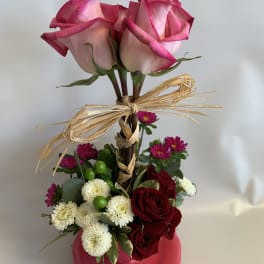 Pink roses in a vase with red and white flowers