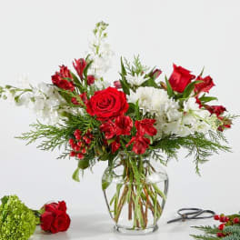 Red and white floral arrangement in a clear glass vase