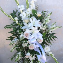 Tall white floral standing spray with lilies and roses on an easel