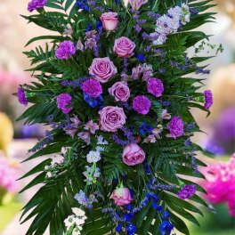 Tall standing floral spray with pink roses and purple blooms on a metal easel