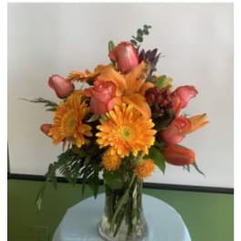 Orange and pink mixed bouquet in a clear glass vase