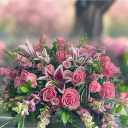 Pink rose and lily funeral spray on a casket
