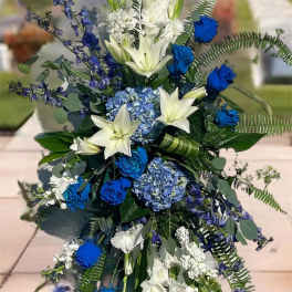 Tall blue and white floral standing spray on an easel