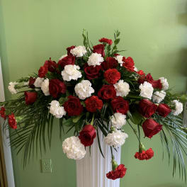 Red roses and white carnations in a tall pedestal arrangement