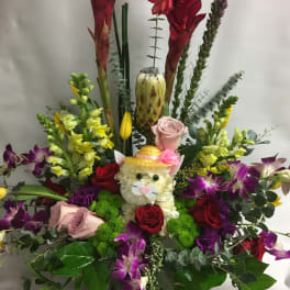Colorful floral arrangement with a cat face centerpiece and orchids