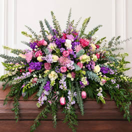 Large mixed bouquet of pink, purple, and white flowers with trailing greenery