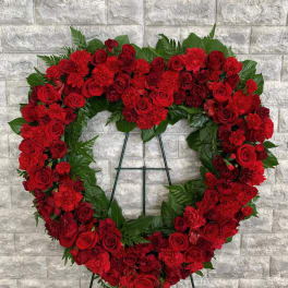 Heart-shaped red floral wreath on a stand