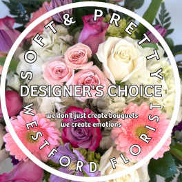 Pastel mixed bouquet of pink and white roses, gerbera daisies, and hydrangeas with designer's choice text overlay.