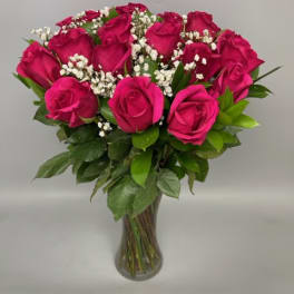Bouquet of hot pink roses with baby's breath in a clear glass vase