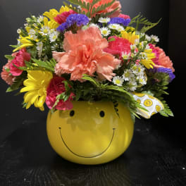 Colorful mixed bouquet in a yellow smiley-face container