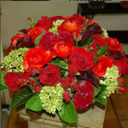 Red and orange rose bouquet with dark calla lilies and green hydrangeas