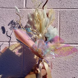 Dried bouquet with white fluffy grasses and iridescent wrap