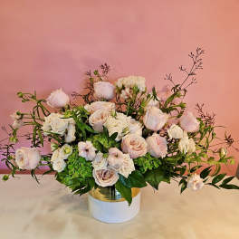 Blush and white rose arrangement in a white vase