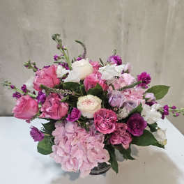 Pink and white rose bouquet with hydrangea in a glass vase