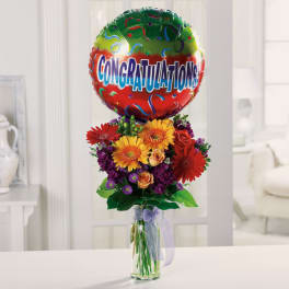 Bouquet of mixed flowers with a congratulations balloon in a glass vase
