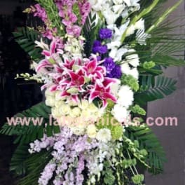 Tall standing floral spray with pink and white lilies and purple accents