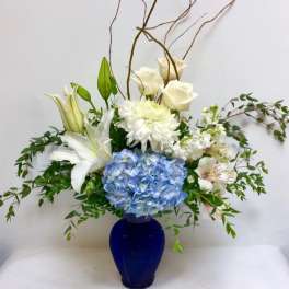 Blue and white floral arrangement in a cobalt vase