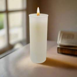 Lit white pillar candle on a table