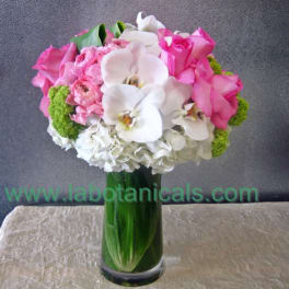 Pink and white bouquet in a tall green glass vase