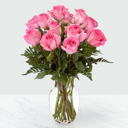 Pink roses arranged in a clear glass vase