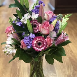 Pink and purple mixed bouquet in a clear glass vase