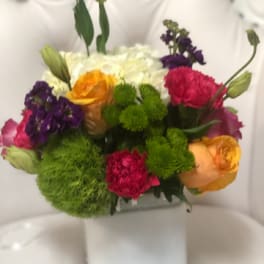 Colorful mixed bouquet in a white square vase