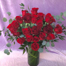 Bouquet of red roses in a glass vase with eucalyptus