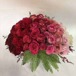 Large bouquet of red and pink roses with fern foliage