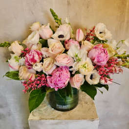 Pink and white flower arrangement in a green vase