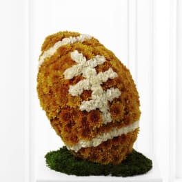 Floral standing spray with orange and white flowers on a green base