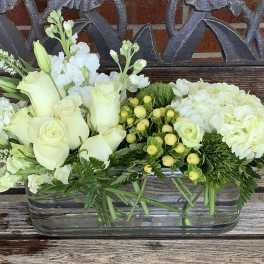 White roses and hydrangeas in a rectangular glass vase