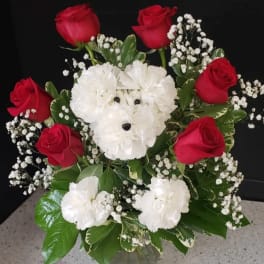 Red roses and white carnations arranged in a vase with baby's breath