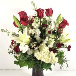 Red roses and white lilies in a dark vase